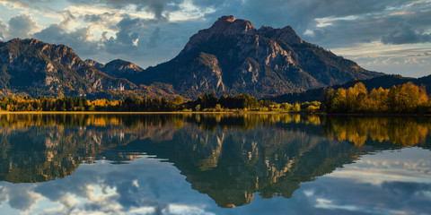 Germany, Bavaria, Ostallgu, Mountains reflected in lake with Neuschwanstein castle in distance