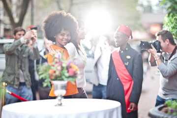 Woman walking on a red carpet with cameras flashing