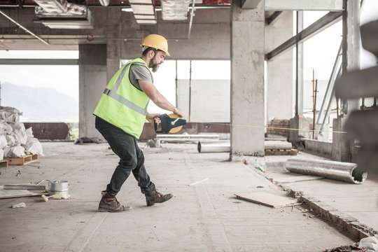 Construction worker using tape measure in construction site