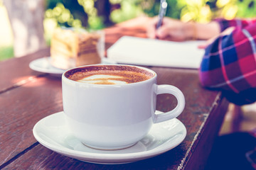 Close up cup of hot coffee on wooden table