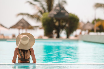 Woman relaxing by the pool in a luxury hotel resort enjoying perfect beach holiday vacation - obrazy, fototapety, plakaty