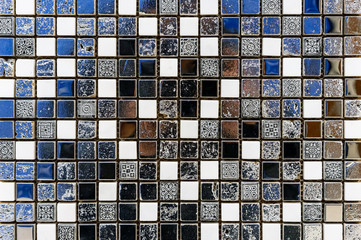 Ceramic mosaic tile in antique style with white, black and blue squares.