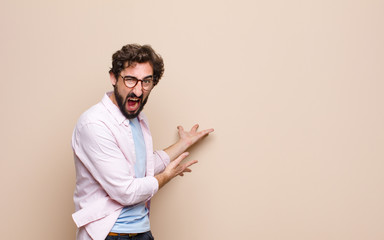 young bearded man expressing a concept against flat wall