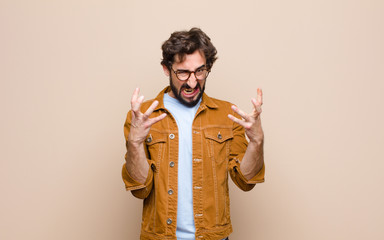 young cool and crazy man against flat wall