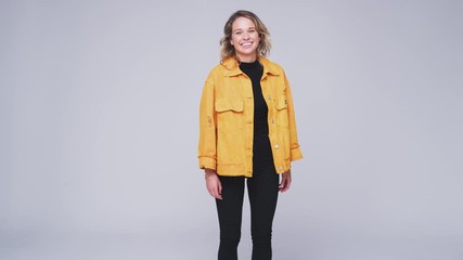 Studio Shot Of Young Woman Walking Into And Out Of Frame Against White Background In Slow Motion