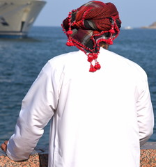 Mann mit rotem Palästinensertuch und weißem Gewand an der Corniche von Muscat