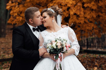 Happy young newly married wedding couple on walk in golden yellow fall autumn park around trees. Relationship love concept. Man woman on nature outdoors