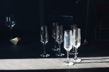 Group of empty flutes on the floor in the sunlight. Flutes are left after the party. Two wineglasses in sunlight.