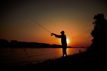 Men fishing on the river on sunset
