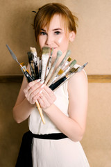 Portrait of a young red-haired girl in the hands of the brush. Modern Art. Inspiration and...