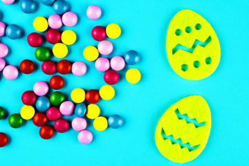 Jelly beans are scattered on a blue background. Easter eggs on a blue background.