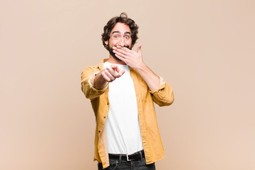 young crazy cool man laughing at you, pointing to camera and making fun of or mocking you against...
