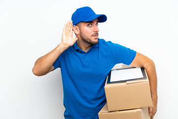 Delivery man over isolated white background listening something