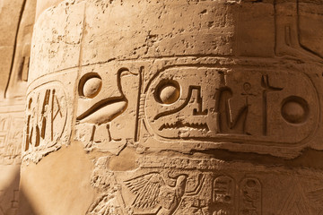 Karnak Temple, complex of Amun-Re. Embossed hieroglyphics on columns. Great Hypostyle Hall. Luxor Governorate, Egypt.