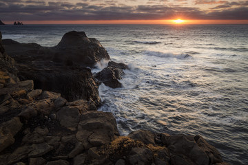 Dyrholaey lighthouse over black sand beach in Iceland