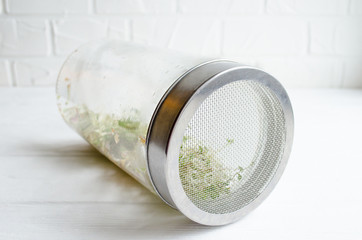 Glass jar with a metal lid and sieve, for microgreen, young sprouts of radish, lucerne, fenugreek plants on white background