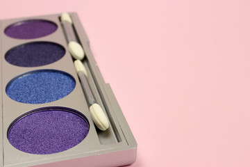 Eye shadow with brush on pink background. Space for text
