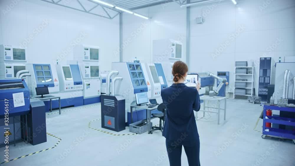 Poster Modern Factory: Female Engineer Uses Digital Tablet Computer with Augmented Reality Software to Visualize Workshop for Room Mapping, Floor Layout. Facility with High-Tech CNC Machinery and Robot Arm
