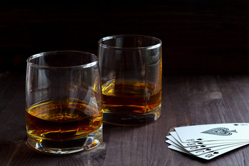 alcoholic drinks. glass of whiskey on a black background. two glasses of whiskey on a wooden...