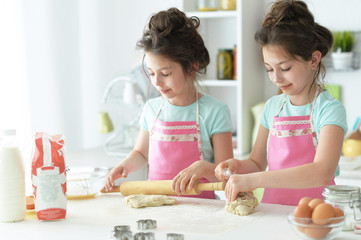 Cute girls baking in the kitchen at home