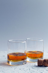 alcoholic drinks. glass of whiskey with ice on a blue background. two glasses of whiskey on a white background.