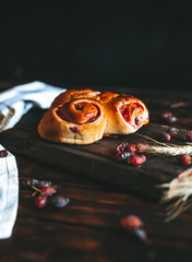 
Sweet cake with strawberry jam and cherries on an old wooden background, with wheat spices in a yellow plate.
Sweet pastry for breakfast