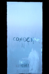 Inscription condense on glass with drops of condensed vapor with drops of water. Close up detail of moisture condensation problems. Hot water vapor condenses on the cold glass in the bathroom