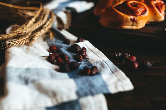 
Sweet cake with strawberry jam and cherries on an old wooden background, with wheat spices in a yellow plate.
Sweet pastry for breakfast