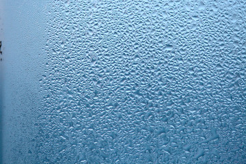 Close Up detail of moisture condensation problems, water drops, texture colorful water drop. Hot water vapor condensed on the cold window glass