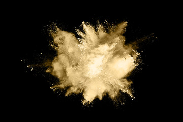 Golden powder explosion on black background. Freeze motion.