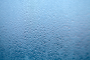 Close Up detail of moisture condensation problems, water drops, texture colorful water drop. Hot water vapor condensed on the cold window glass