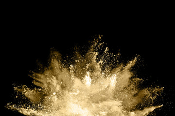 Golden powder explosion on black background. Freeze motion.