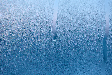 Close Up detail of moisture condensation problems, water drops, texture colorful water drop. Hot water vapor condensed on the cold window glass