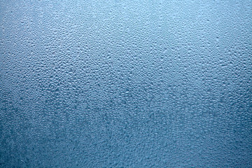 Drops of condensed steam, water drops. Close up detail of moisture condensation problems. Hot water vapor condensed on the cold window glass