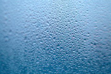 Drops of condensed steam, water drops. Close up detail of moisture condensation problems. Hot water vapor condensed on the cold window glass