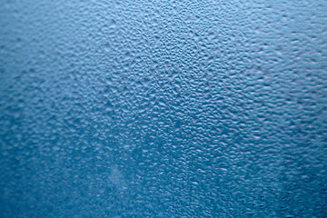 Drops of condensed steam, water drops. Close up detail of moisture condensation problems. Hot water vapor condensed on the cold window glass