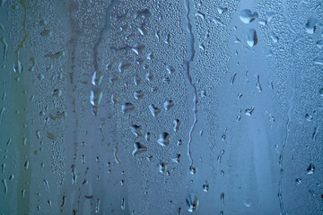 Drops of condensed steam, water drops. Close up detail of moisture condensation problems. Hot water vapor condensed on the cold window glass