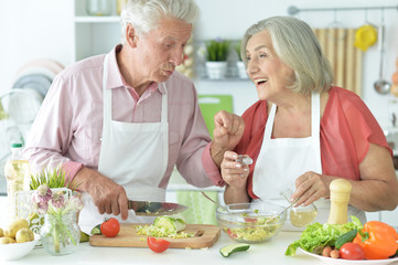 Obraz na płótnie Canvas Portrait of senior couple cooking together at kitchen