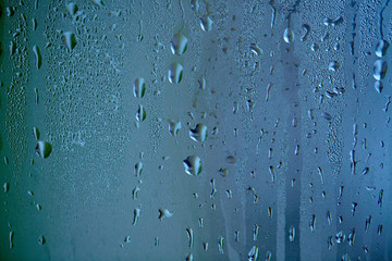 Drops of condensed steam, water drops. Close up detail of moisture condensation problems. Hot water vapor condensed on the cold window glass
