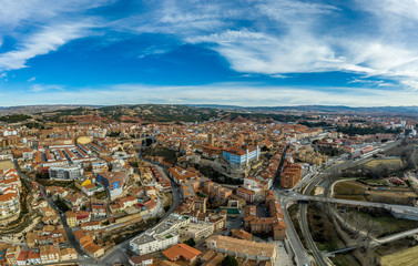 Fototapeta na wymiar Aerial panoramic view of Teruel Spain with medieval city walls, viaduct, aquaduct and semi circular tower on a sunny winter afternoon 