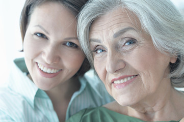 Close up portrait of senior woman with daughter at home