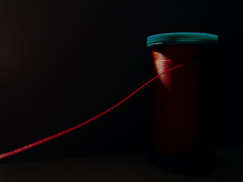 Spool of red thread on a sewing machine