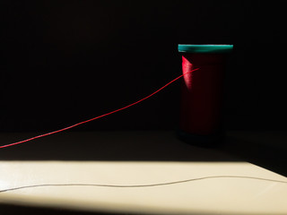 Spool of red thread on a sewing machine