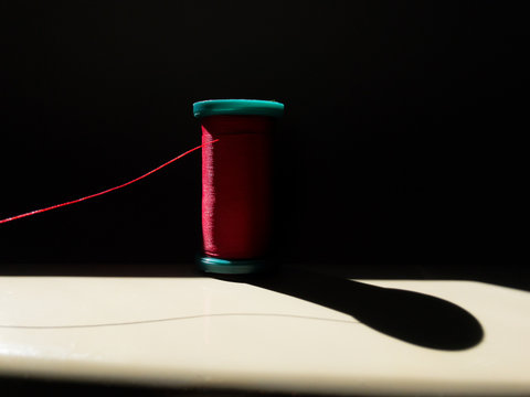 Spool of red thread on a sewing machine