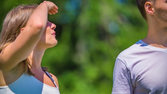 Young millennial couple enjoy a nature hike walking on a beautiful summer day