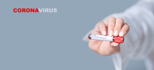 Nurse holding a positive blood test result for the new rapidly spreading Coronavirus. Text phrase Coronavirus on grey background