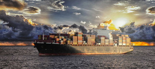 Mighty container ships in ocean at sunrise underway performing import and export marine cargo...