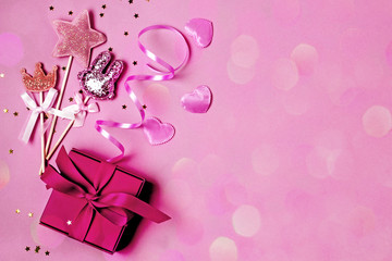 Pink festive background with sparkles and gifts, copy space, flat lay