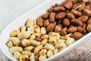 Peanuts in a white cup an old wooden floor. ramadan food. healthy nutrition. healthy food. vegetarian snack