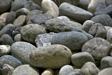 Different in shape and color gray beige rounded stones.